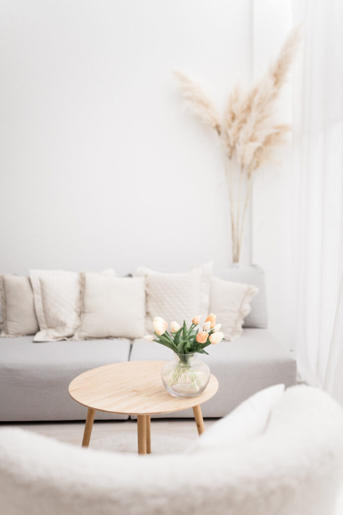 Dekorierte Sitzecke mit Sessel, Sofa und Blumen.